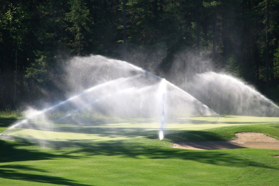 large sprinklers water a turf grass gold course